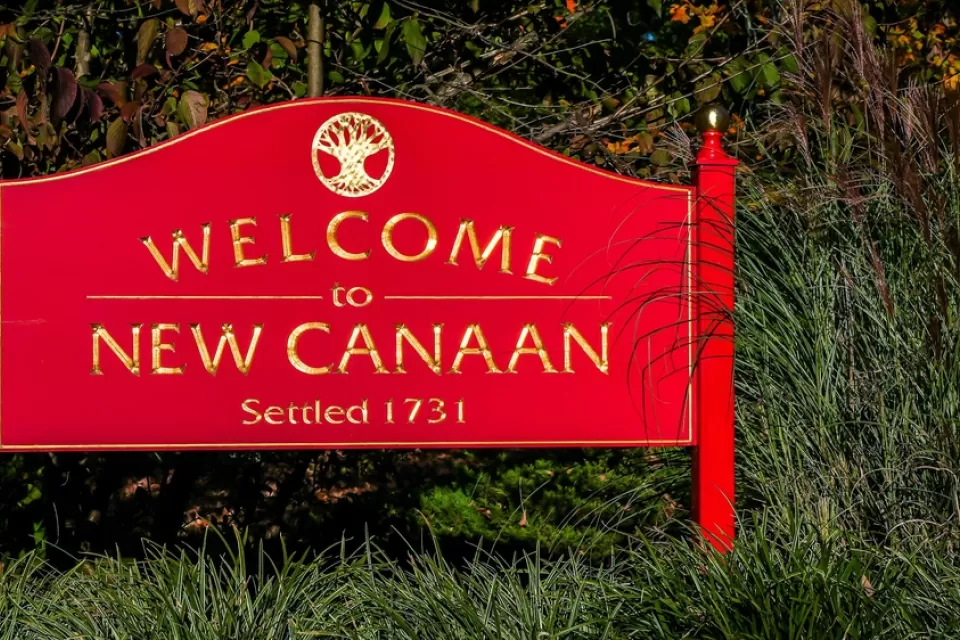 A red sign reads, “Welcome to New Canaan.”